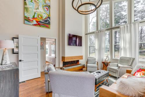a living room with chairs and a fireplace at Modern Lake House Retreat with Deck on Pickwick Lake in Counce