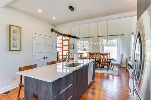 an open kitchen and dining room with a large island at Modern Lake House Retreat with Deck on Pickwick Lake in Counce