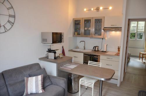 une cuisine et un salon avec un canapé et une table dans l'établissement Charmant appartement 4 personnes, à Cauterets