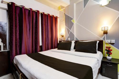 two beds in a room with red curtains at Hotel Raaz Luxury Near Delhi Airport in New Delhi