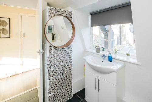 a bathroom with a sink and a mirror at Bright Fitzrovia Studio in London