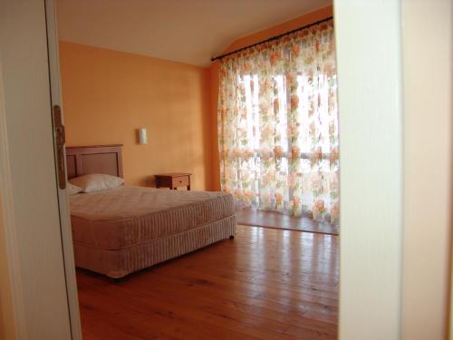 a bedroom with a bed and a large window at Morski Briz Houses in Topola