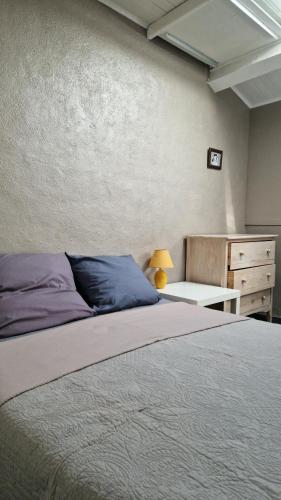 a bedroom with a large bed and a dresser at La petite Glycine in Sérignan