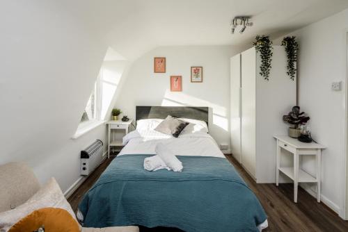 a bedroom with a bed with a blue blanket at Bright Fitzrovia Studio in London
