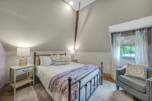 a bedroom with a bed and a chair and a window at Luxury Loft in Historic Carriage House in Kennett Square