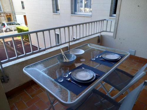 a table with plates and glasses on a balcony at ANDISE in Courseulles-sur-Mer