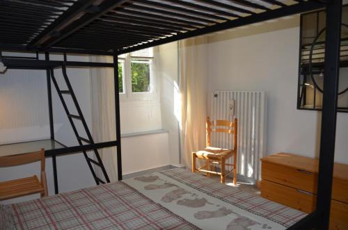 une chambre avec un lit superposé et une chaise dans l'établissement Charmant appartement 4 personnes, à Cauterets