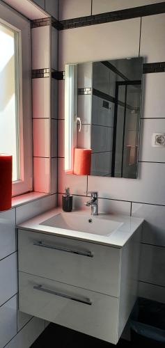 y baño con lavabo blanco y espejo. en Holiday House Berekfürdő, en Berekfürdő