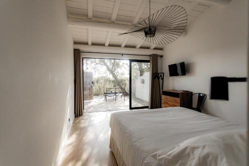 - une chambre avec un lit et une vue sur une terrasse dans l'établissement Mas de la Fouque - Hôtel & Spa, à Saintes-Maries-de-la-Mer