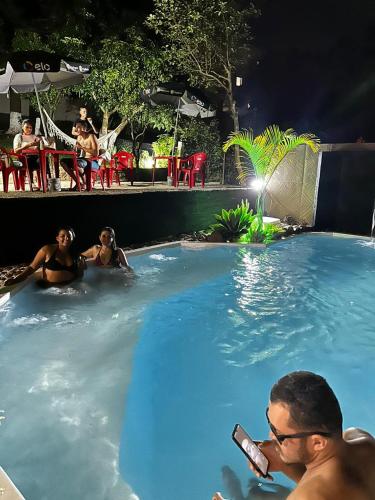 a group of people in a swimming pool at night at HOSTEL FAMILIA ZANATTA in Caxias do Sul