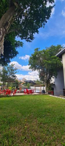 a group of red picnic tables in a park at HOSTEL FAMILIA ZANATTA in Caxias do Sul