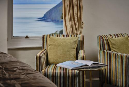 a book sitting on a table next to a chair at Highcliffe House in Lynton