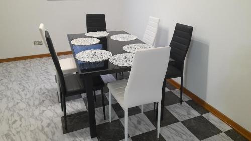 a black dining room table with black and white chairs at Apartmani Delas 2 in Pješčana Uvala 