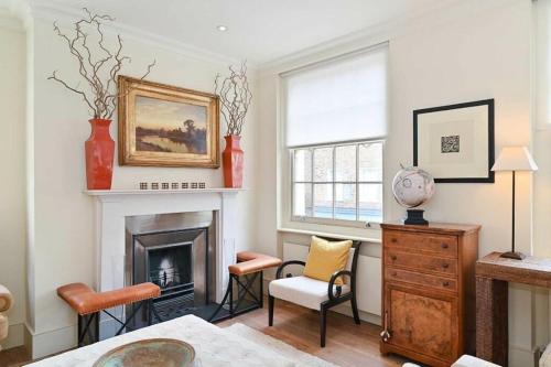 sala de estar con chimenea y 2 sillas en Royal Regency Residence - Sleeps 8 en Londres