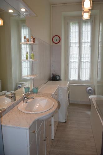 La salle de bains blanche est pourvue d'un lavabo et d'un lave-linge. dans l'établissement Charmant appartement 4 personnes, à Cauterets