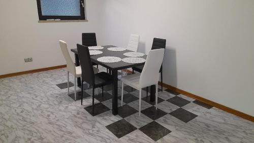 a black dining room table with black and white chairs at Apartmani Delas 2 in Pješčana Uvala 