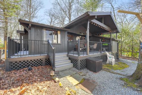 a small house with a porch and a chair at Near Lake and Trails Rustic Newland Cabin with Deck! in Newland