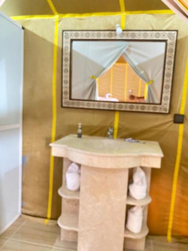 a bathroom with a sink and a mirror at Explore merzouga luxury camp in Merzouga