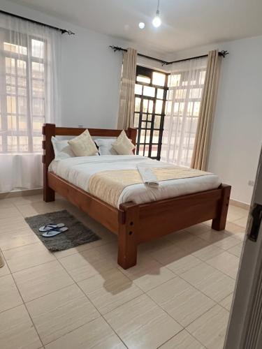 ein Schlafzimmer mit einem Bett in einem Zimmer mit Fenstern in der Unterkunft The comfortplace Naivasha in Naivasha