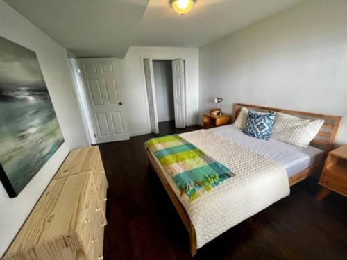 a bedroom with a large bed and a table at Cozy Waterfront Cottage in Victoria Harbour in Victoria Harbour