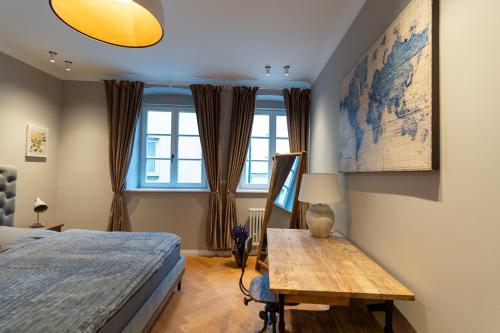 um quarto com uma cama, uma mesa e uma janela em Wunderschönes Altbaujuwel in ruhiger Innenstadtlage em Augsburg