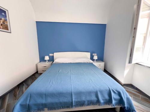 um quarto azul com uma cama e duas mesas de cabeceira em Casa vacanze centro storico Procida em Procida