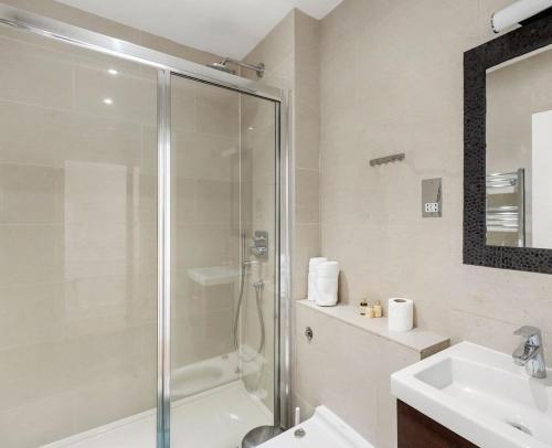 a bathroom with a shower and a sink at Exclusive 2-Bedroom Apartment in London