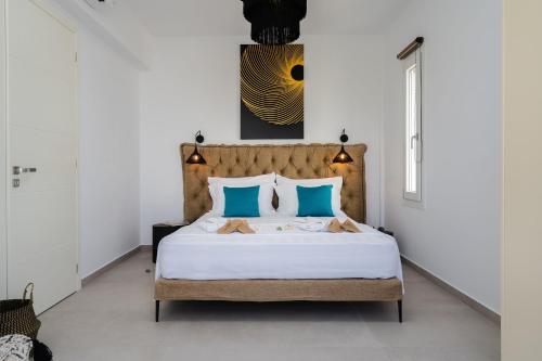 a bedroom with a large bed with blue pillows at Naxos Superior Villas in Kastraki Naxou