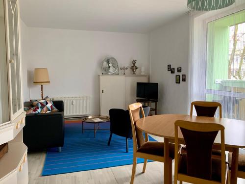 sala de estar con mesa, sillas y sofá en Home Wilma en Berlín