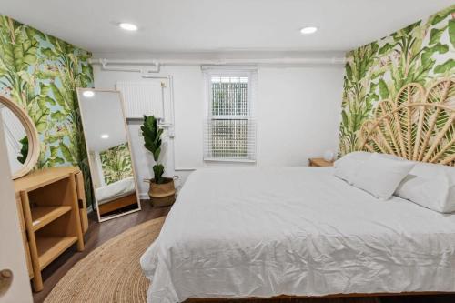 a bedroom with a large white bed and a mirror at Quiet Convenient 2-Family House - Tropical Design in Atlantic City