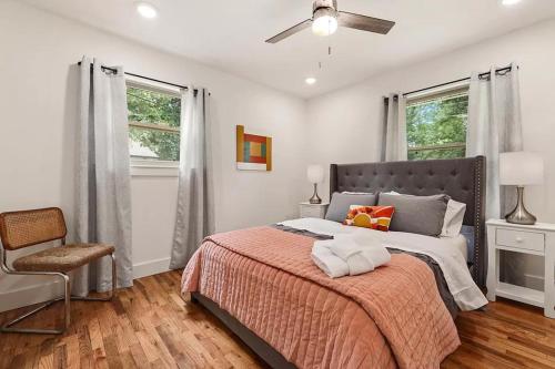 een slaapkamer met een bed, een stoel en ramen bij Tranquil Home in Bentonville in Bentonville