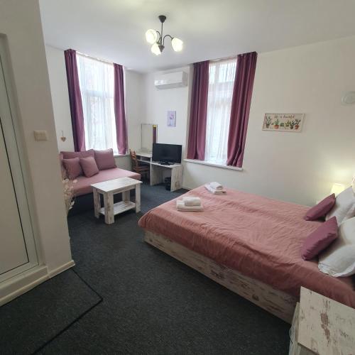 a bedroom with a bed and a living room with a couch at Guest House Gurkov in Veliko Tŭrnovo