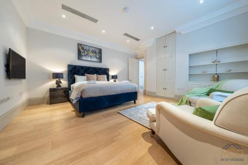 a bedroom with a king sized bed and a couch at Royal 4 Bedroom Apartment in Mayfair in London