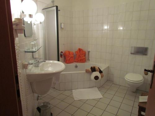 ein Badezimmer mit einem WC, einer Badewanne und einem Waschbecken in der Unterkunft Ferien- und Reitsport Hotel Brunnenhof in Suhlendorf