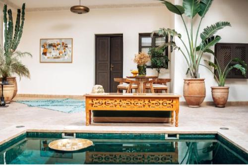 a living room with a table and a pool at Riad Deha & Spa in Marrakesh