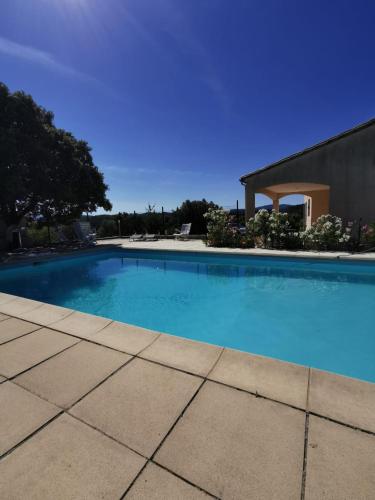 une grande piscine bleue devant un immeuble dans l'établissement VILLA FAMILIALE, PISCINE, VUE IMPRENABLE -en été la location est de samedi à samedi-, à Saint Jean du Pin