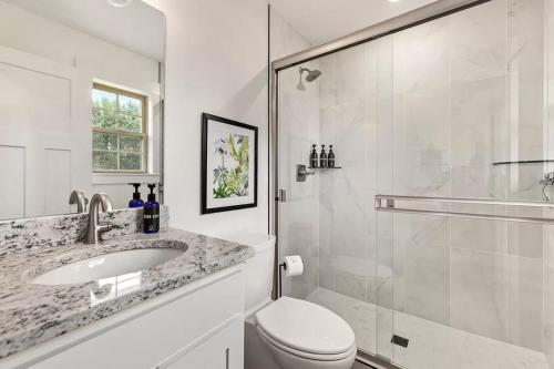 a bathroom with a toilet and a sink and a shower at Tranquil Home in Bentonville in Bentonville