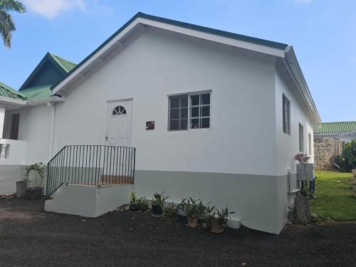 a white house with a large garage at Dalkeith Greathouse in Knockpatrick