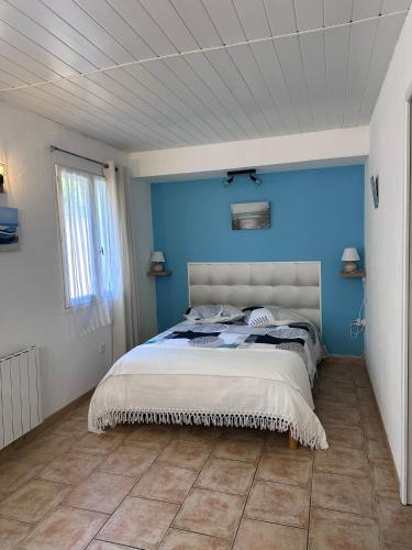 une chambre avec un mur bleu et un lit dans l'établissement Appartement spacieux de plein pied avec 2 chambres, cuisine, salon, terrasse à 2 minutes de la plage, à Gruissan