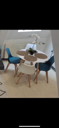 une table et des chaises avec un vase au-dessus dans l'établissement Le petit Treguier, à Tréguier