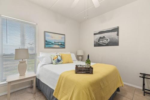 a bedroom with a bed and a table with a yellow blanket at Beachview Get-AWAY @ Fantasy Circle in South Padre Island