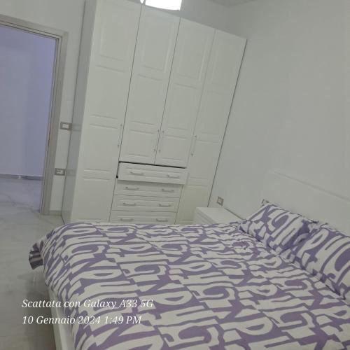 een witte slaapkamer met een bed en een dressoir bij Casa Sarà in Pogradec