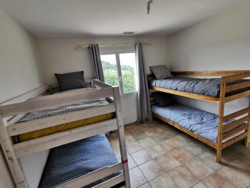 a room with two bunk beds and a window at VILLA FAMILIALE, PISCINE, VUE IMPRENABLE -en été la location est de samedi à samedi- in Saint Jean du Pin