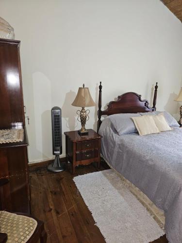 a bedroom with a bed and a table with a lamp at Dalkeith Greathouse in Knockpatrick
