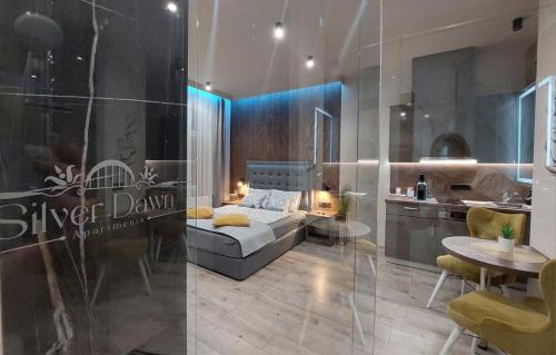 Silver Dawn Apartments في سيجد: غرفة بها أريكة وطاولة ومطبخ