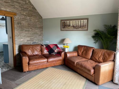 a living room with two brown leather couches at Luxury, Spacious Cottage in the Black Mountains in Hereford