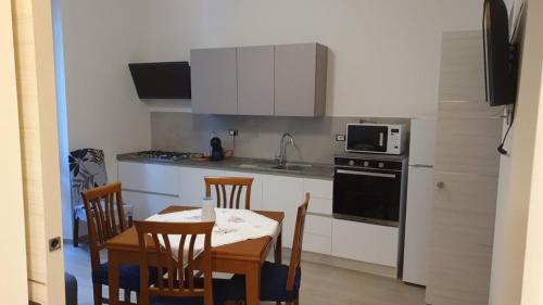 a kitchen with a table and chairs and a microwave at ILLY HOUSE in Alghero