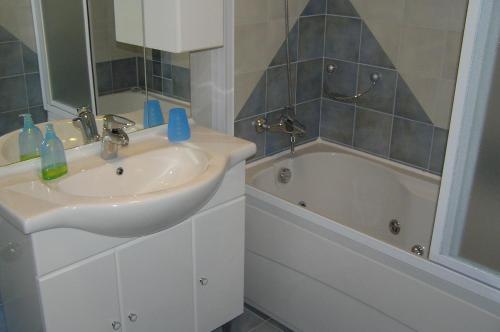 a bathroom with a sink and a bath tub at Villa Simfonija in Malinska