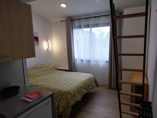 ein kleines Schlafzimmer mit einem Bett und einer Leiter in der Unterkunft studio Indépendant et climatisé. arrivée autonome in Bègles