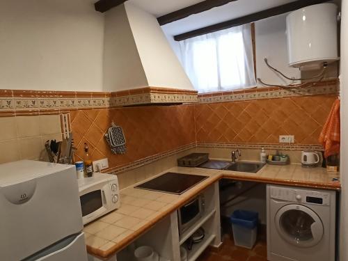 a small kitchen with a sink and a microwave at Casa la Baronia in Chulilla